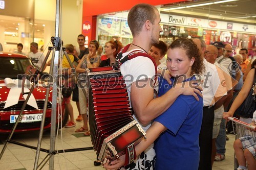 Obiskovalec in članica harmonikarskega orkestra Pustotnik