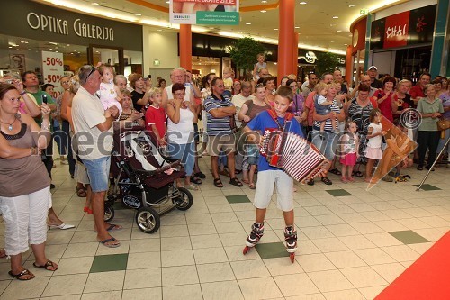 Član harmonikarskega orkestra Pustotnik in obiskovalci