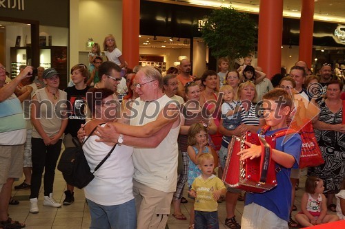 Član harmonikarskega orkestra Pustotnik in obiskovalci