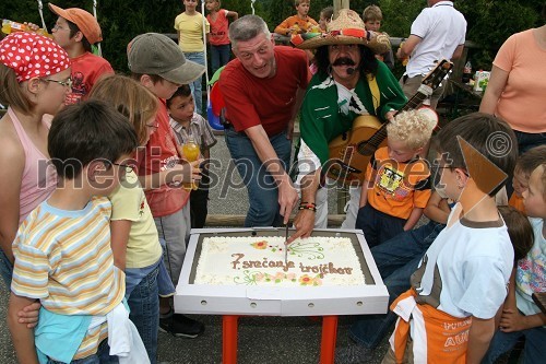 Slobodan Mageš-Magi, organizator srečanja in Slavc Kovačič - Spidi s trojčki pri rezanju torte