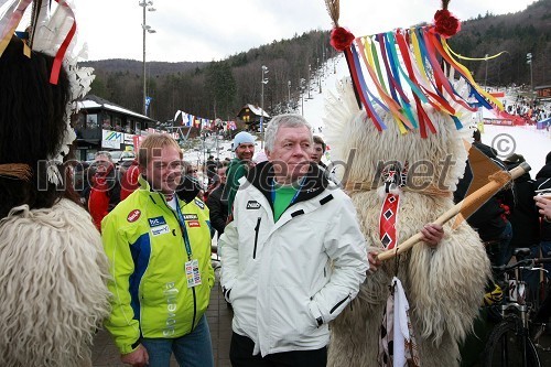 Bojan Križaj, nekdanji slovenski smučar s spremljevalko in Tone Vogrinec s kurenti